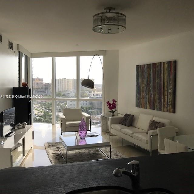 living room with a wall of windows, a view of city, and visible vents