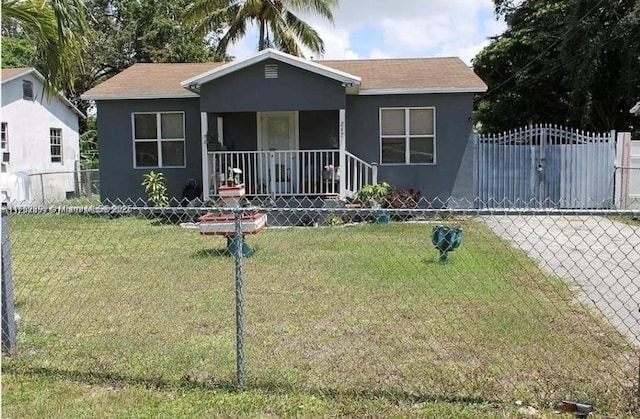 bungalow-style home featuring a fenced front yard, a front yard, a porch, and stucco siding