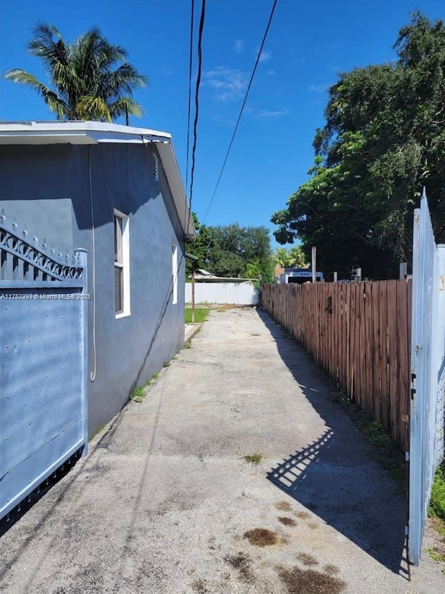 view of side of home featuring fence and stucco siding