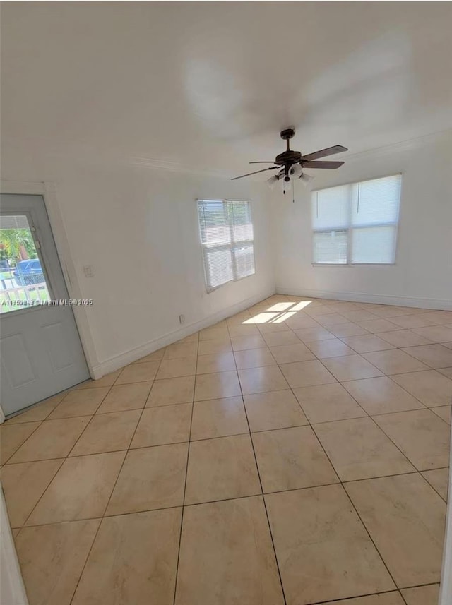 unfurnished room with light tile patterned floors, ceiling fan, and baseboards