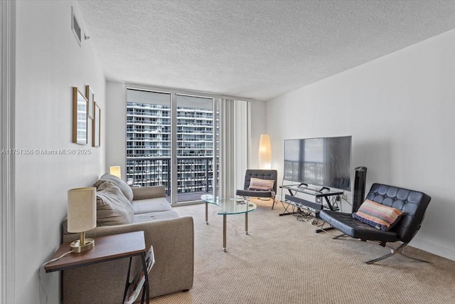 carpeted living area with visible vents, a wall of windows, and a textured ceiling