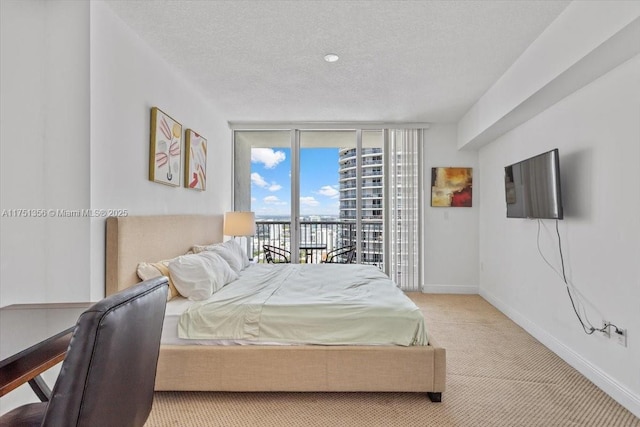 bedroom with a textured ceiling, light carpet, baseboards, access to outside, and a wall of windows