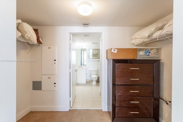 walk in closet with light tile patterned floors, visible vents, and light colored carpet