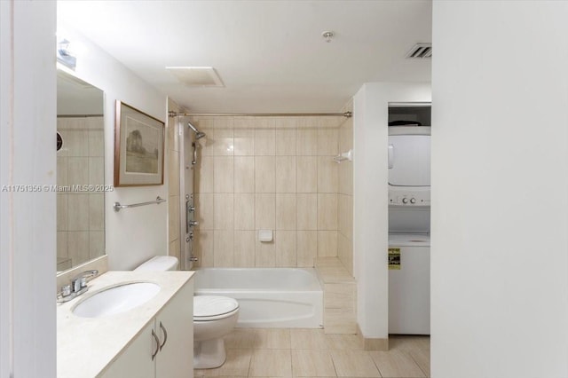 bathroom featuring stacked washer and clothes dryer, visible vents, shower / bath combination, toilet, and vanity