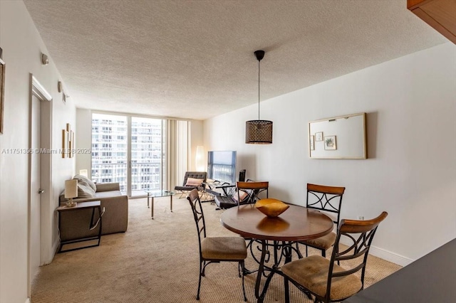 dining area with light carpet, baseboards, floor to ceiling windows, and a textured ceiling