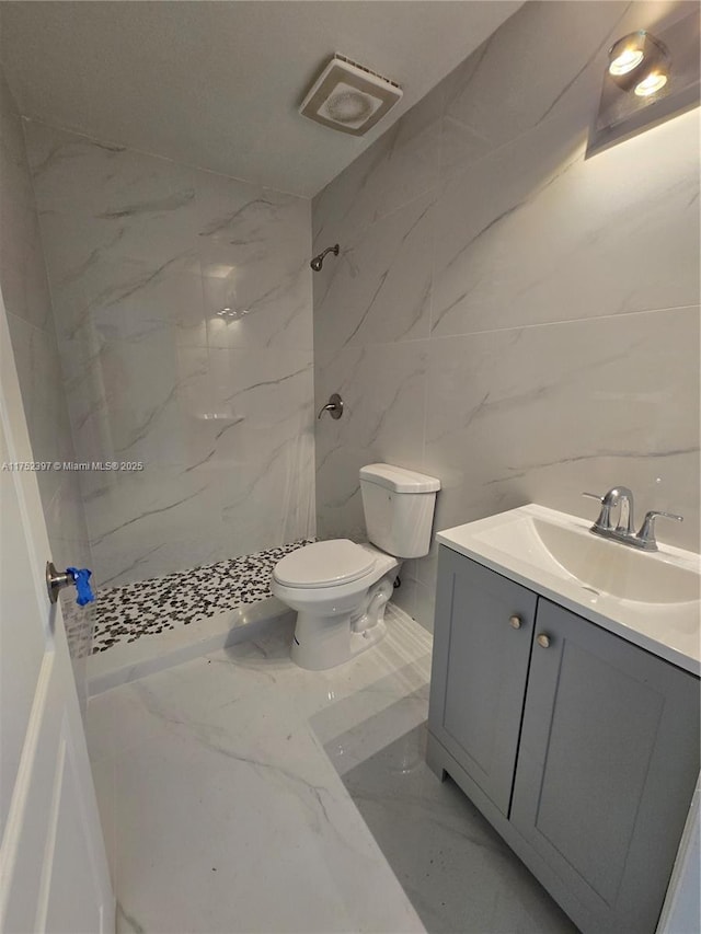 full bathroom with marble finish floor, toilet, vanity, and a marble finish shower