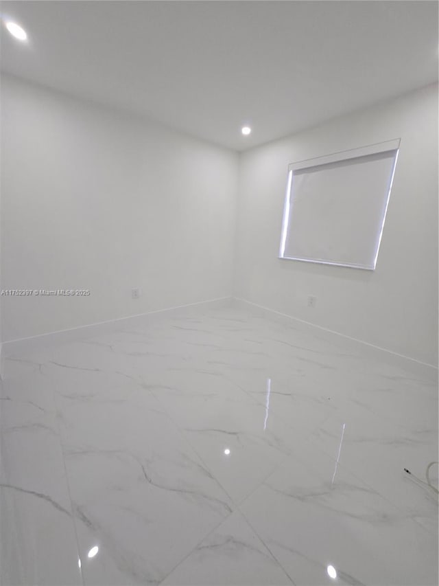 empty room with baseboards, marble finish floor, and recessed lighting