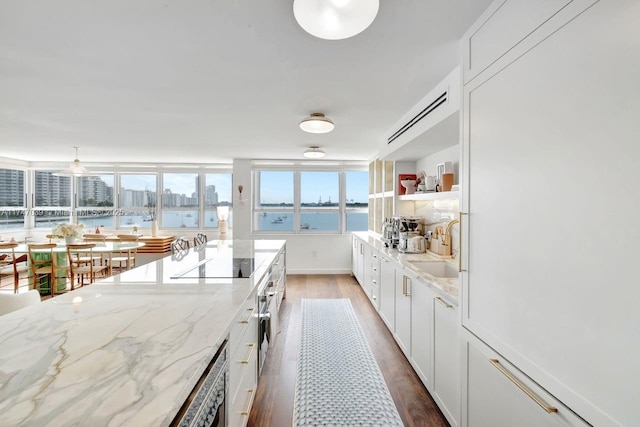 kitchen featuring black electric stovetop, open shelves, white cabinetry, a sink, and wood finished floors