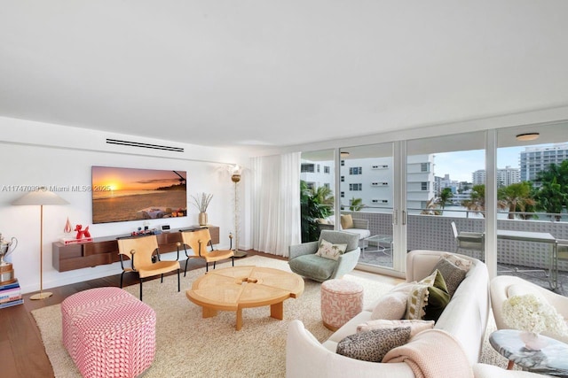 living room featuring a city view, wood finished floors, and a wall of windows