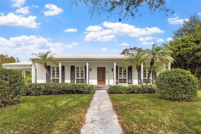 view of front of house with stucco siding, covered porch, and a front yard