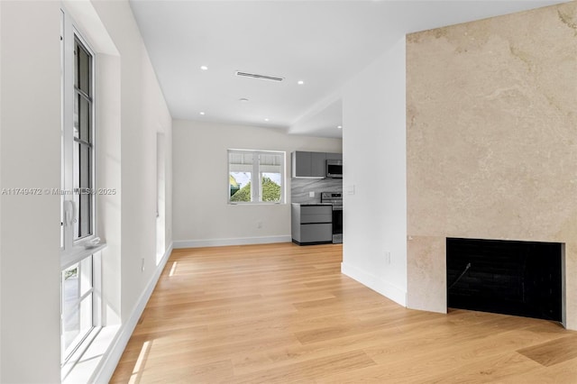 interior space featuring light wood-type flooring, visible vents, baseboards, and recessed lighting