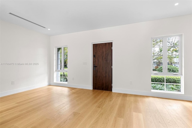 spare room featuring recessed lighting, baseboards, and light wood finished floors