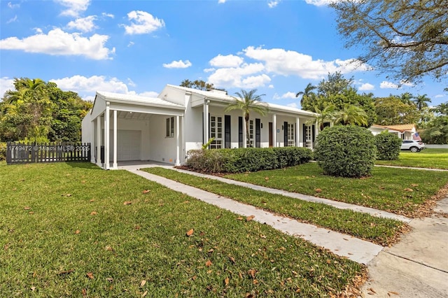 view of front of home with a front yard, fence, driveway, and stucco siding