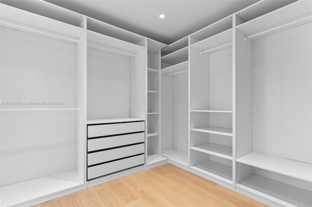 walk in closet with wood finished floors