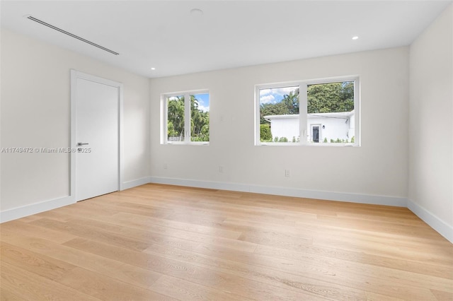 empty room featuring light wood-type flooring, baseboards, and recessed lighting