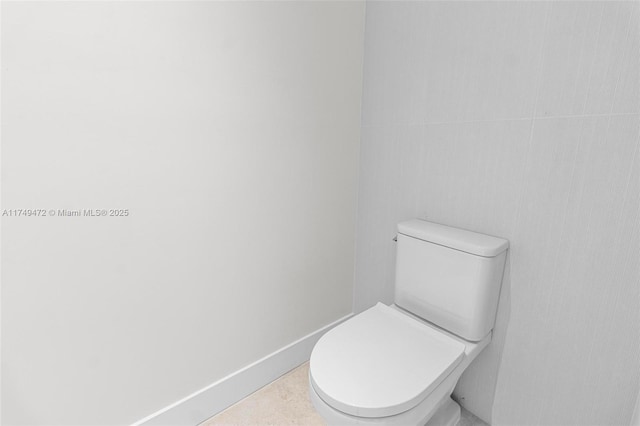 bathroom with toilet and baseboards