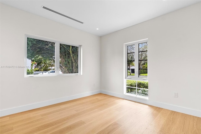 empty room featuring baseboards and light wood-style floors