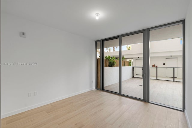 1116 N Ocean Blvd Unit 304, Pompano Beach, FL 33062 - unfurnished room featuring wood finished floors, baseboards, and expansive windows