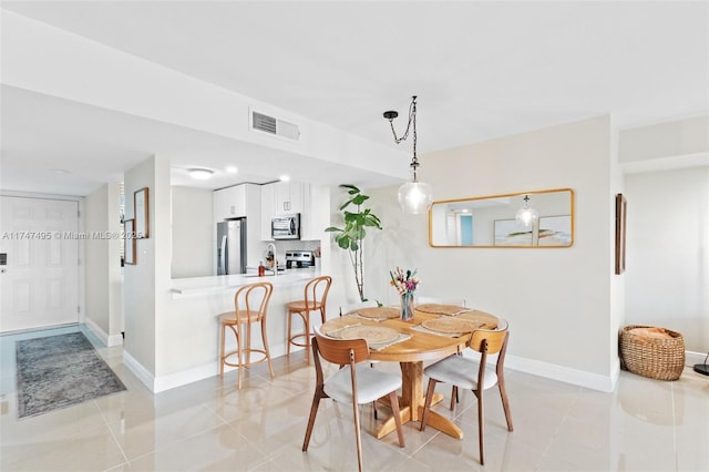 dining area with light tile patterned floors, baseboards, and visible vents