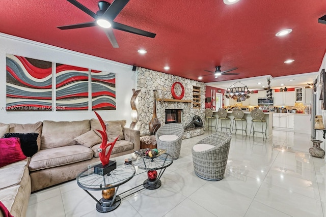 living area featuring a textured ceiling, light tile patterned floors, recessed lighting, a fireplace, and a ceiling fan