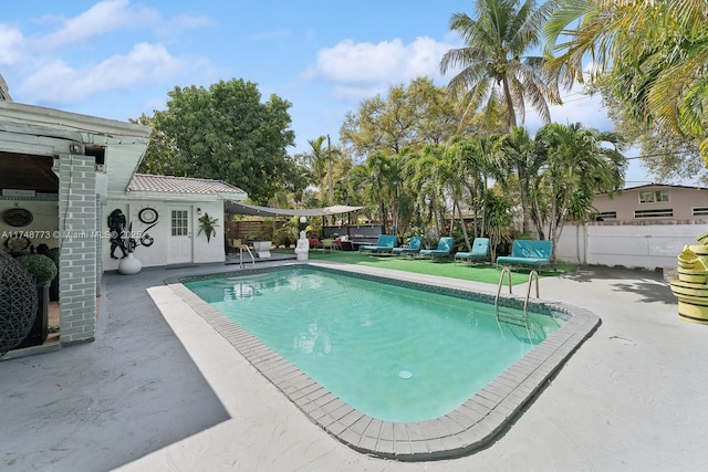 view of swimming pool featuring a patio area, fence, and a fenced in pool