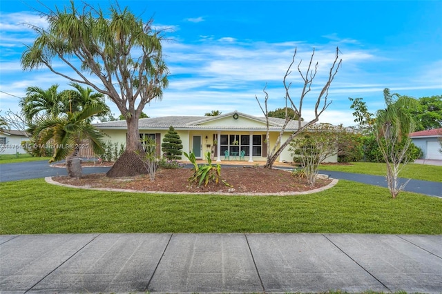 single story home featuring aphalt driveway, a tile roof, a front lawn, and stucco siding