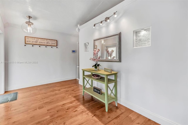 hallway featuring light wood-style flooring and baseboards