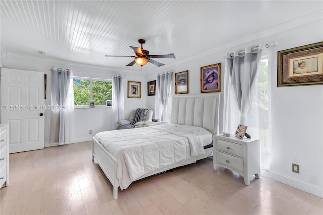 bedroom with baseboards, light wood finished floors, a ceiling fan, and crown molding