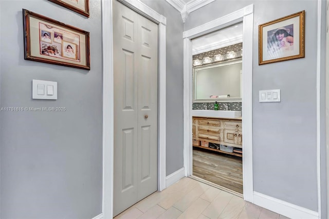 hall featuring light wood-style flooring and baseboards