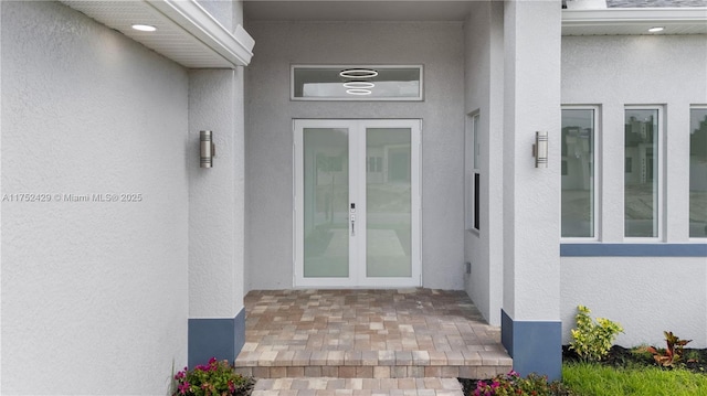 property entrance with french doors and stucco siding