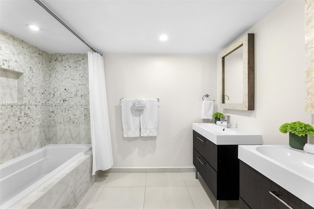 bathroom featuring tiled shower / bath, two vanities, a sink, baseboards, and tile patterned floors