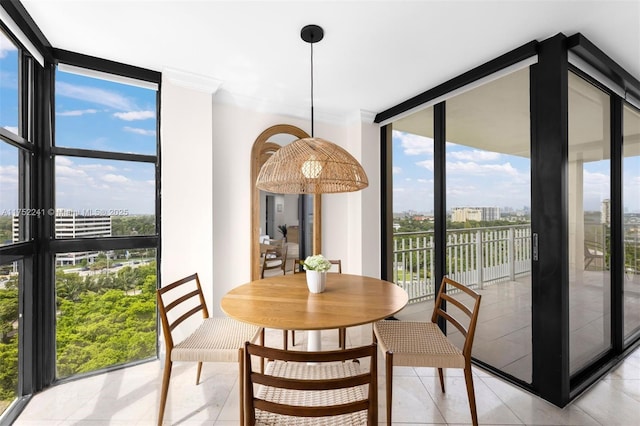 dining area featuring crown molding, light tile patterned floors, a wealth of natural light, and floor to ceiling windows