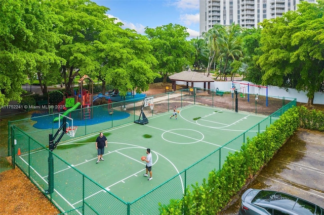 view of basketball court with community basketball court, fence, and playground community