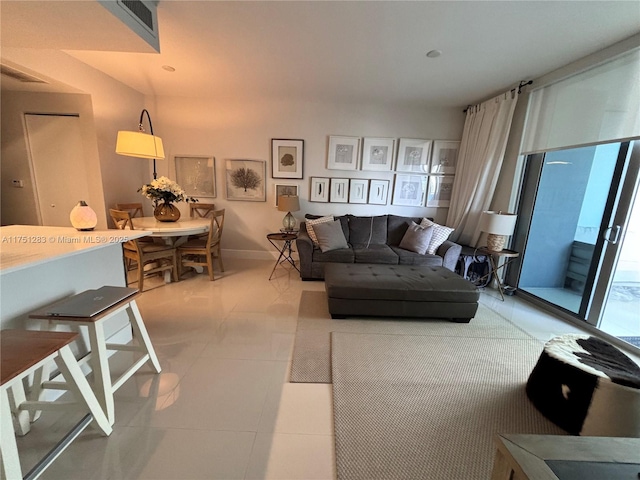 living area featuring light tile patterned flooring and baseboards