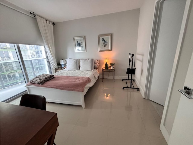 bedroom with light tile patterned flooring and baseboards