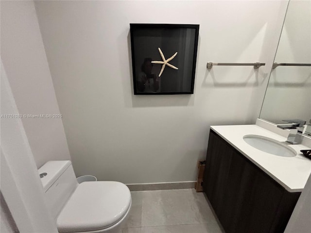 bathroom with toilet, baseboards, and vanity