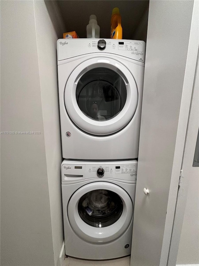 washroom featuring stacked washer / drying machine