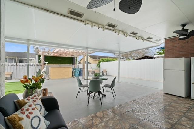 view of patio / terrace with outdoor dining area, fence, and ceiling fan