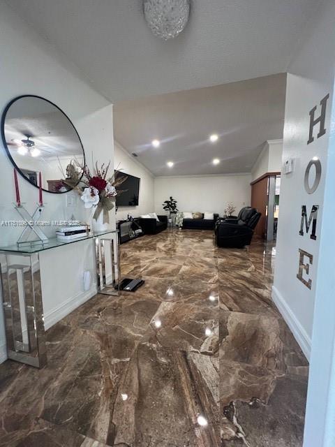 interior space with lofted ceiling, marble finish floor, and baseboards