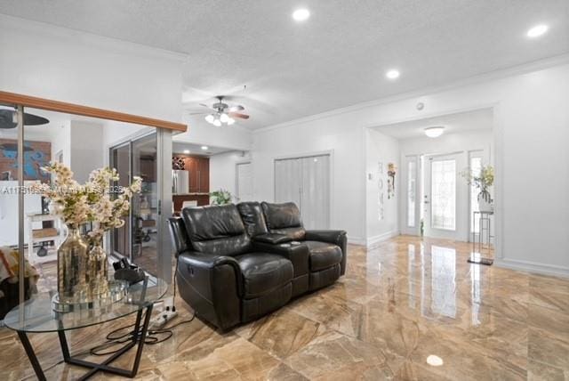 living area featuring marble finish floor, ornamental molding, baseboards, and a ceiling fan