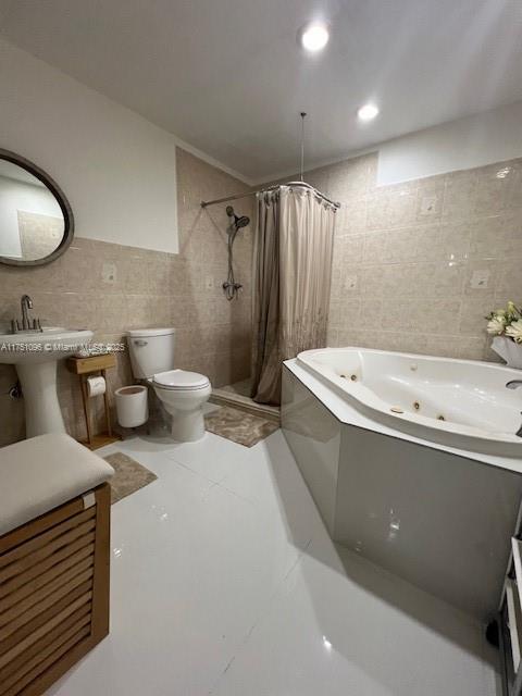 bathroom featuring toilet, a jetted tub, a shower stall, tile walls, and recessed lighting