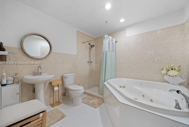 full bath with a tub with jets, toilet, tile walls, a stall shower, and tile patterned floors
