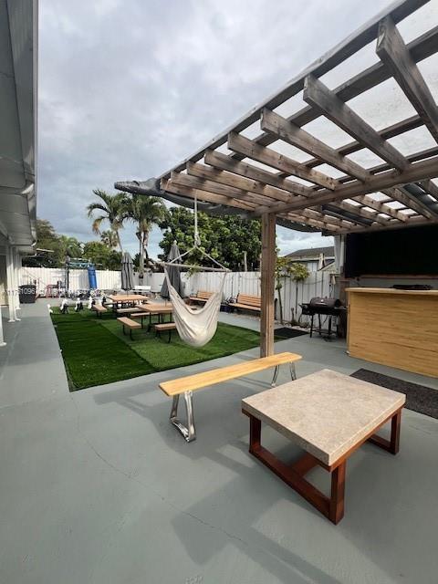 view of home's community with fence, a pergola, and a patio