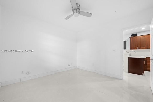empty room featuring baseboards and a ceiling fan