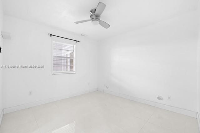 spare room with light tile patterned flooring, ceiling fan, and baseboards