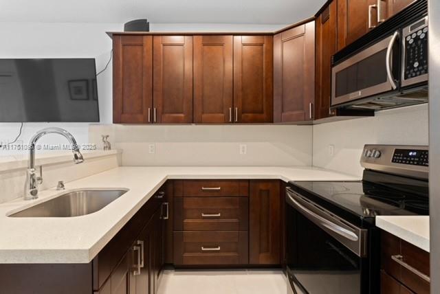 kitchen featuring light countertops, appliances with stainless steel finishes, and a sink