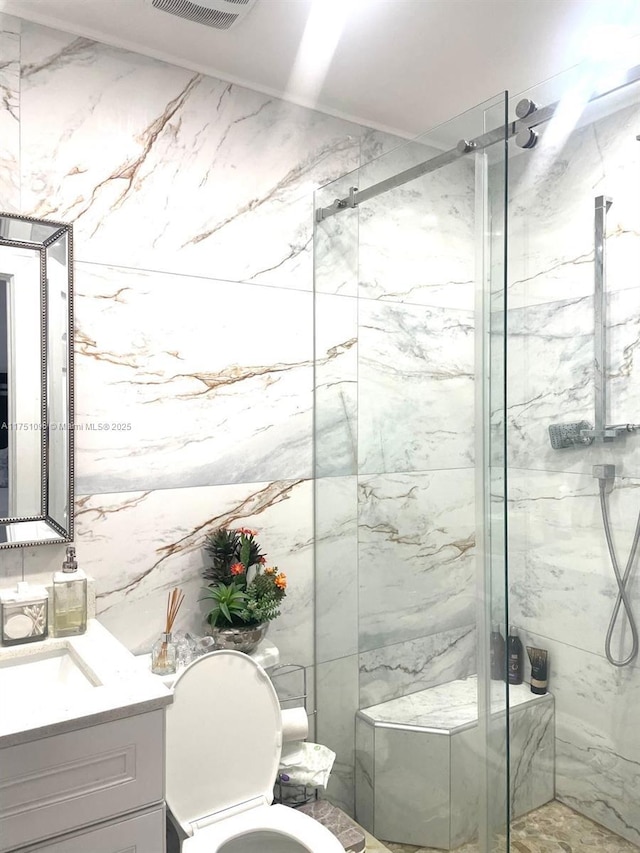 full bath featuring visible vents, toilet, vanity, and a marble finish shower