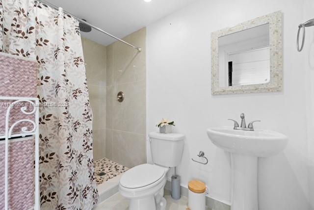 full bathroom with a sink, toilet, and a shower stall