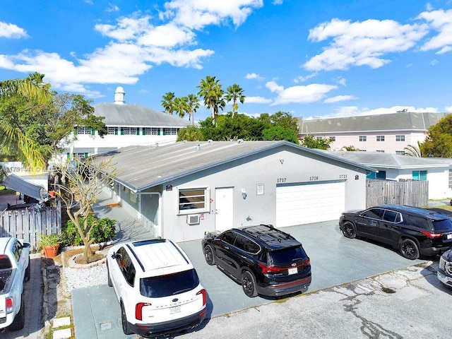 single story home with a garage, concrete driveway, fence, and stucco siding