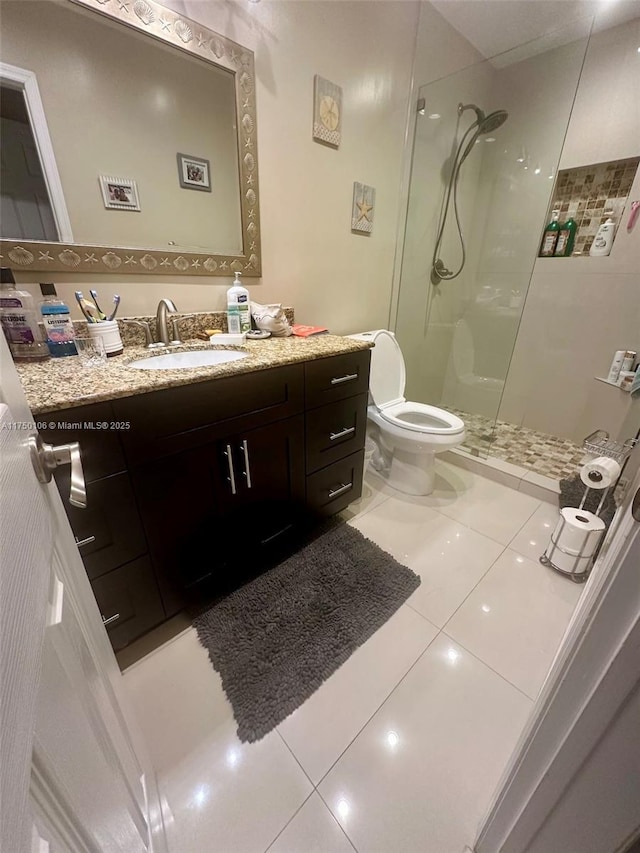 bathroom featuring walk in shower, vanity, toilet, and tile patterned floors